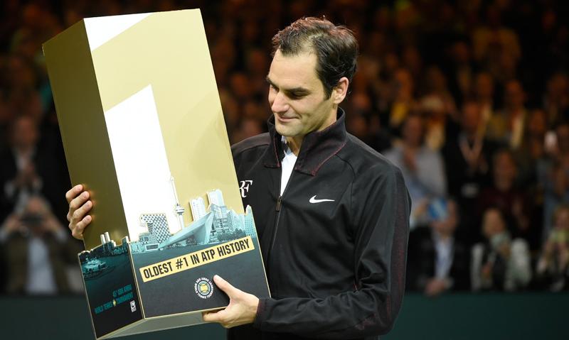 Roger Federer poses with the trophy after defeating Robin Haase of the Netherlands 4-6, 6-1, 6-1 to regain number ranking at the age of 36. - AFP     