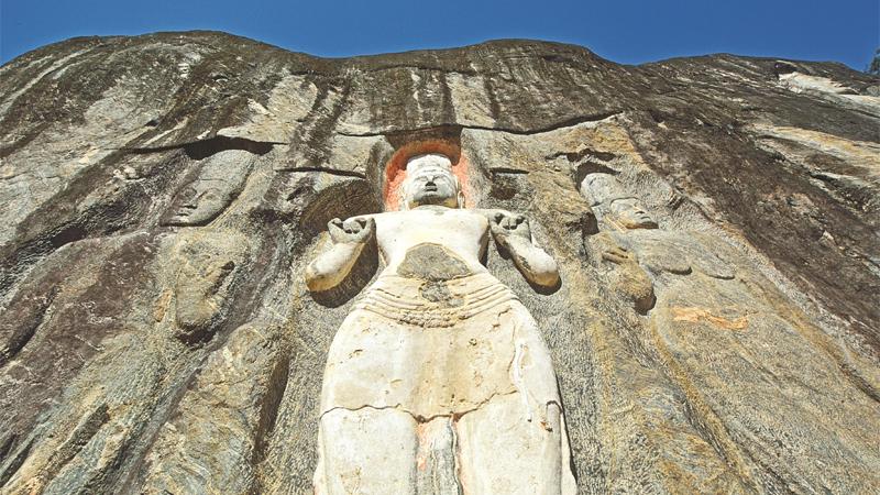 The figures at Buduruwagala in relief on the face of large rocks   