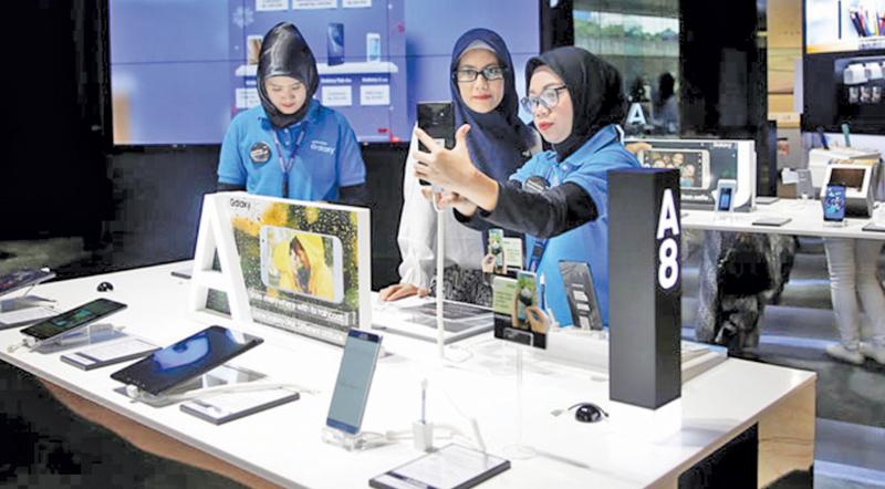  A salesperson shows a customer the latest smartphones in a showroom in Jakarta, Indonesia: the use of mobile internet services continues to grow rapidly in the country    