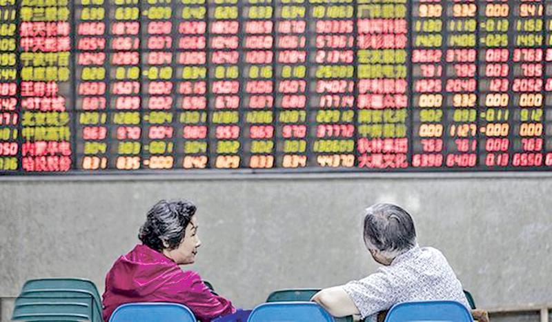 Investors sit in front of an electronic stock board at a securities brokerage in Shanghai, June 9, 2017. Pic: VCG 