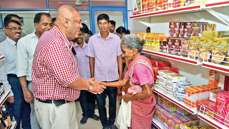 Minister Mangala Samaraweera heartily greets a customer at the Co-op shop  Pix: Rukmal Gamage