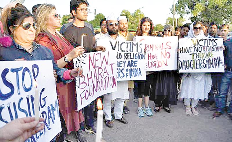 Indian demonstrators gather at the India Gate monument for a candlelight vigil in protest over the gang rape and murder of an eight-year-old girl, in New Delhi on April 14, 2018. The brutal gang rape and murder of the child has triggered nationwide outrage, inflamed communal tensions and shone a fresh critical light on the prevalence of sexual crimes.  AFP PHOTO