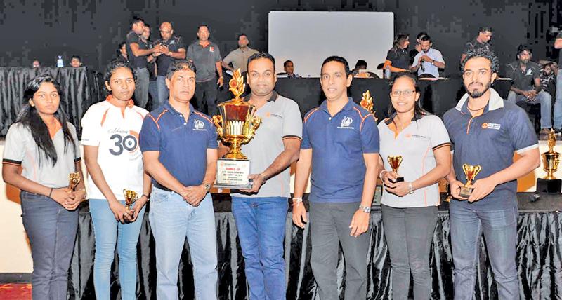 HR Department Team with the Overall Champions trophy flanked by Tharaka Ranwala, Senior Deputy General Manager – Consumer Banking, Sampath Bank PLC (3rd from left) and Maheel Kuragama, Assistant General  Manager – Operations, Sampath Bank PLC