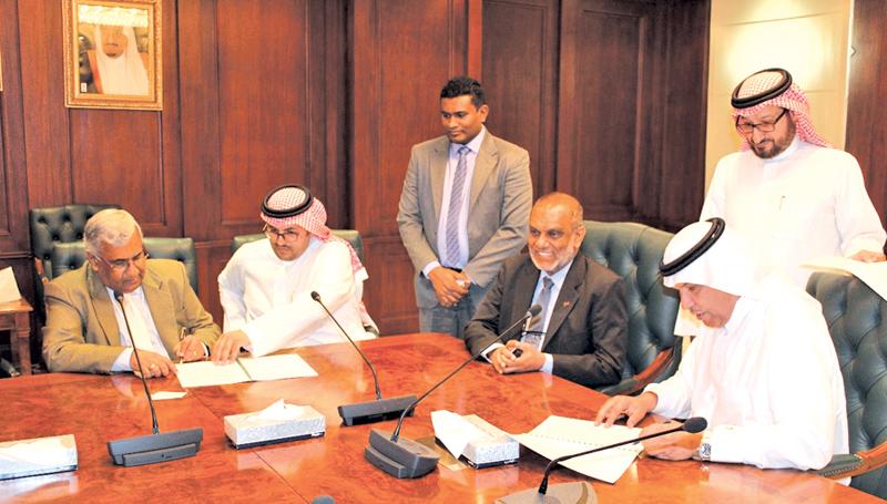 Managing Director of Selmo Pvt. Ltd., Anton Hemantha (left) and Director General of the Saudi Export Program, Ahmed Al Ghannam (extreme right), sign the agreement in the presence of Sri Lankan Ambassador Azmi Thassim at the SFD headquarters in Riyadh last week.     
