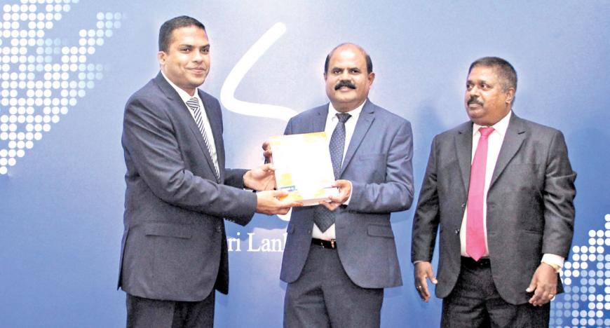 The first print copy of the SLT Rainbow Pages Directory 2018/19 being presented to Minister Harin Fernando by Chairman - Sri Lanka Telecom, Kumarasinghe Sirisena  and Chief Executive Officer - SLT Rainbow Pages, Malraj Balapitiya 