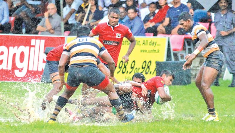 A Peterite forward brings down a Kingswood opponent in their muddy match at Havelock Park  Pic: Samantha Weerasiri