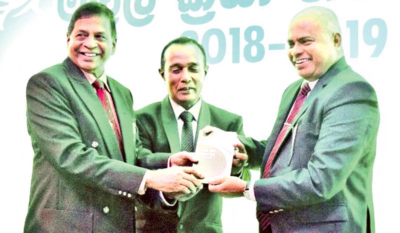 Sunil Hettirachchi(right) secretary Ministry of  Education receiving the copy of rule and regulation of track and field from Sunil Jayaweera.    