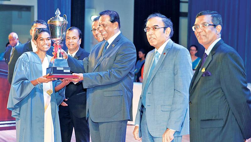 Minister Amaratunga presenting the Ceylon Hotel School Graduates Association Trophy for the Most Outstanding Graduate to B. Rengaswamy.     