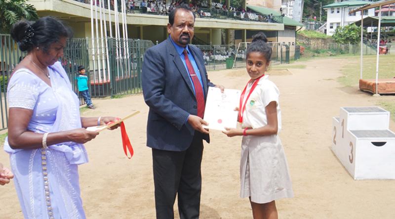 Himansa Herath of Iris House, the Under 14 Champion athlete (girls)- receiving her award from the Chief Guest.  