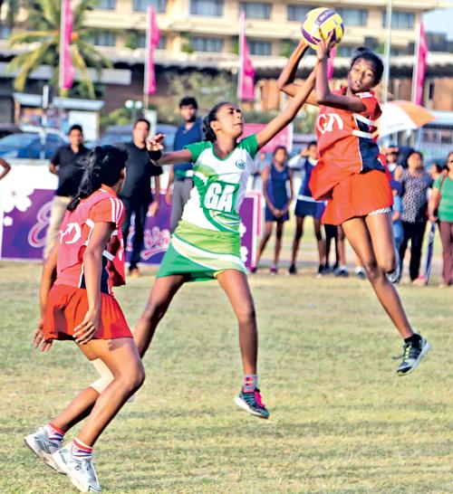 Players from Holy Family Convent Kurunegala (red) and St. Bridget’s Convent compete in their Eva netball championship match at the Air Force ground in Colombo yesterday (Pic by Thilak Perera)    