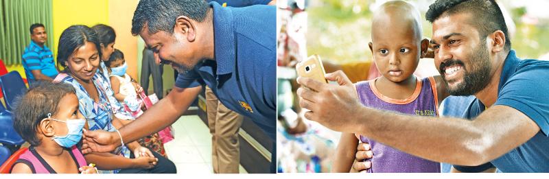 Rangana Herath talks to a child -Aggressive fast bowler Lahiru Kumara shows his gentle side as he takes a selfie with a young boy 