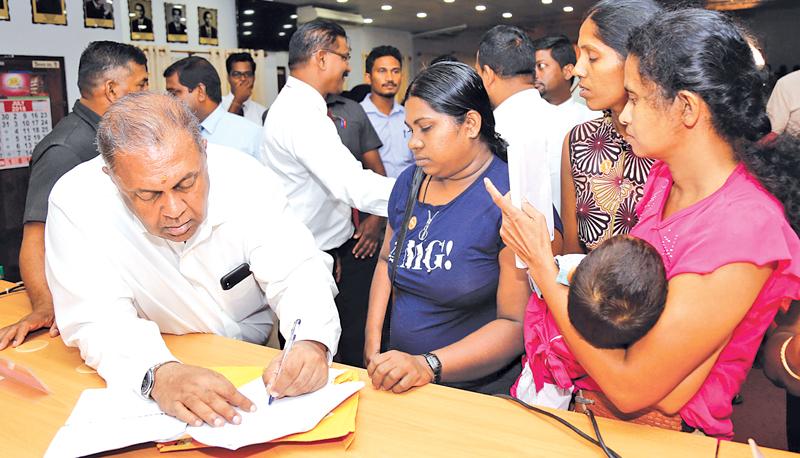 Finance Minister Mangala Samaraweera taking the burden off debt-affected families by providing written assurances that the Govt. would write off their loans