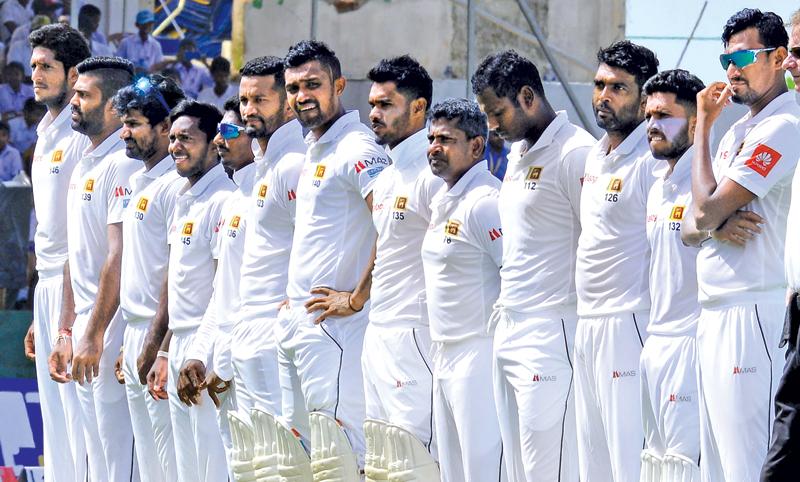 Sri Lankan cricketers stand to attention before the start of a match in this file photo taken by Saman Mendis