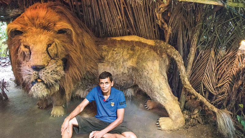 PRIDE OF THE ZOO: Creator Dharmakumara Wettasinghe poses in front of his creation of the lion in the “Sinha waadiya,” model zoo