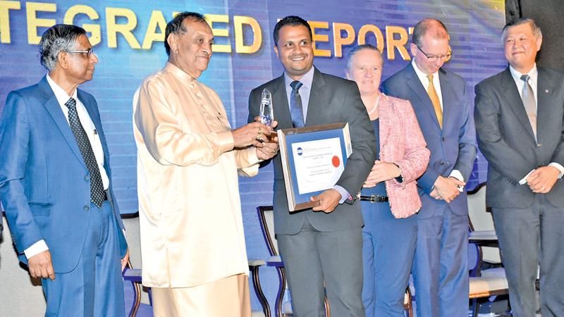 ‘Ten Best Integrated Reports’ award being presented to PLC’s Chief Manager - Finance, Omal Sumanasiri by the Speaker Karu Jayasuriya  
