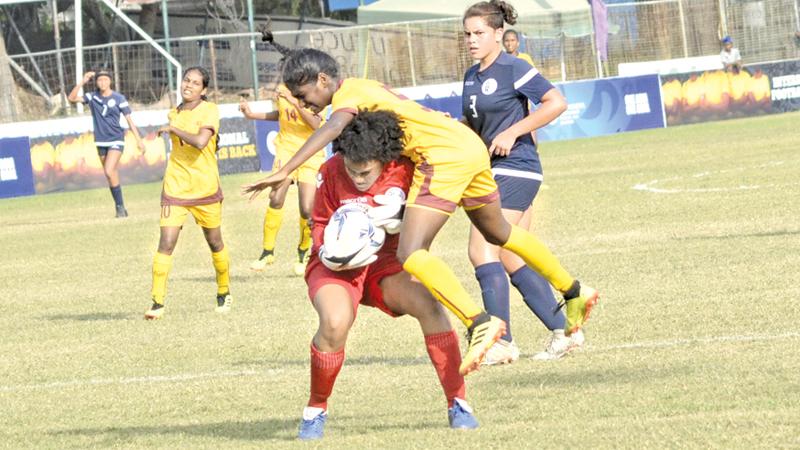 Sri Lanka’s Senuri Bandara (in yellow) collides with Guam’s goal-keeper Kiarra Annabella   