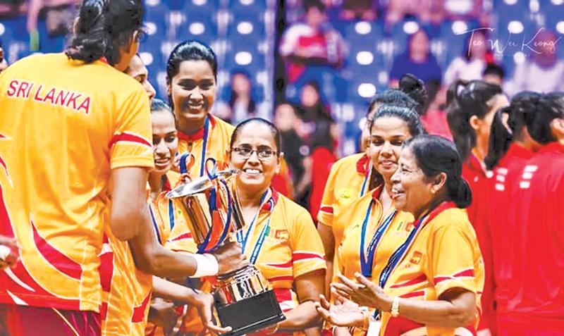 Thilaka Jinadasa is greeted by her jubilant players with the Asia Cup won in Singapore last week in the presence of Trixie Nanayakkara      