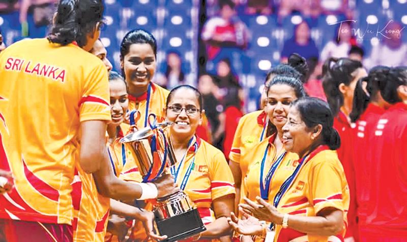 Thilaka Jinadasa is greeted by her jubilant players with the Asia Cup won in Singapore last week in the presence of Trixie Nanayakkara