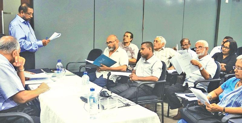 PCCSL CEO Sukumar Rockwood presents the Annual Review of the Press Complaints Commission of Sri Lanka (PCCSL), while PCCSL Board of Directors Chairman Kumar Nadesan looks on. Also in the photograph are members of the PCCSL studying the Annual Review.