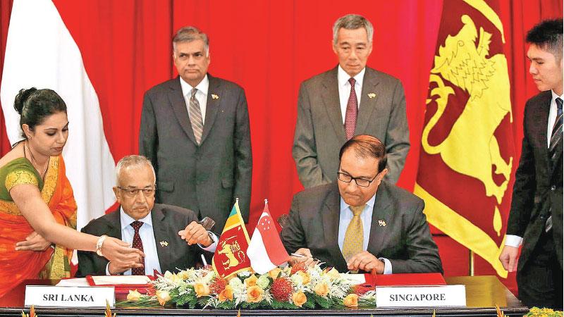 Prime Minister Ranil Wickremesinghe and Singapore Prime Minister Lee Hsien Loong witnessing a Memorandan of Understanding signing ceremony between Development Strategies and International Trade Minister Malik Samarawickrama and Singaporean counterpart S. Iswaran at the Istana in Singapore on 19th July 2016. The MoU marked the commencement of discussions of SLSFTA   