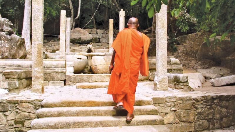 A Monk making his ascent to the cleansing area of the Rajagala Forest Monastery