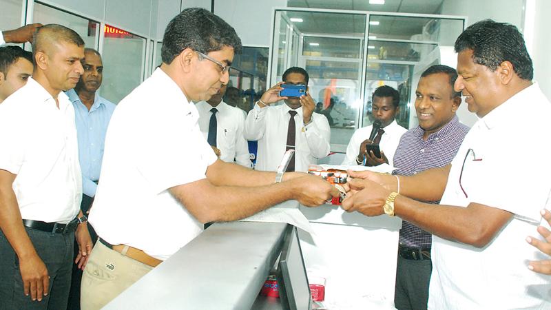 From left: Chairman Ideal Group Nalin Welgama, conducts the first transaction for the newly opened Ideal Motors Spare Parts Store in Panchikawatte with Jagath Jayasinghe of Lumina Motors Ltd. and Automotive Director, Ideal Motors, Chaminda Wanigarathne, cutting the ribbon to declare open the new Ideal Motors spare parts store in Panchikawatte.   