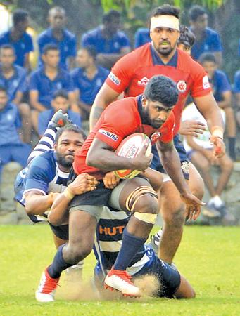 CR flanker Joel Perera attempts to break through a tackle by the Navy defence in their Dialog League match at Welisara yesterday (Picture by Saman Mendis)    