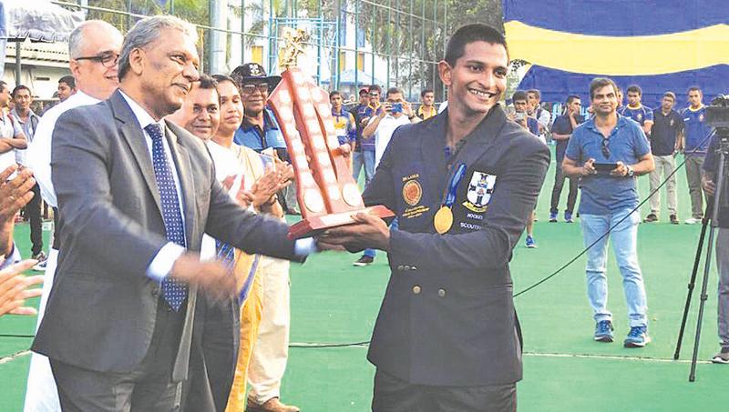 S. Thomas’ College captain Dewmal Palapathwala receives the Orville Abeynaike Memorial Trophy from Dr. Kapila Waidyaratne
