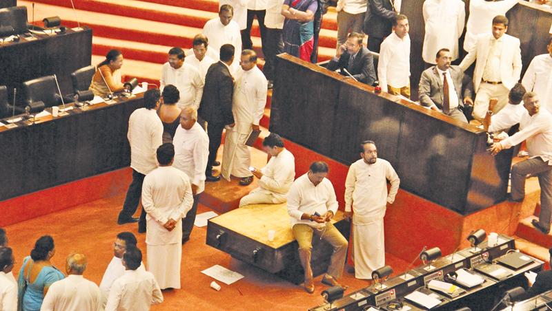 The table on which the highest symbol of respect in Parliament - the Mace, is kept, being thrown to the well of the House and MPs casually seated on the table at the November 16 proceedings that ended abruptly Pic: Hirantha Gunathilaka 