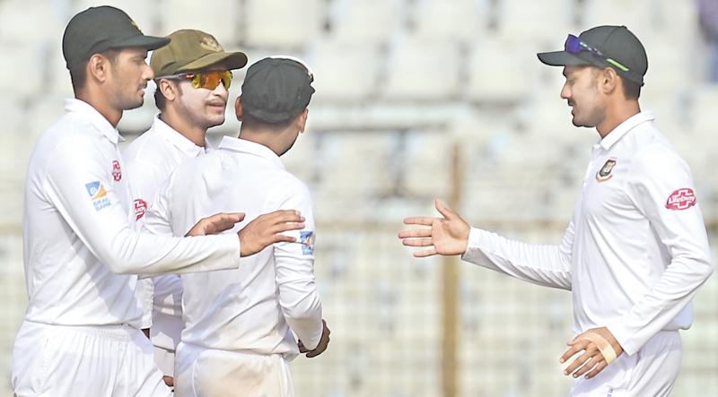Bangladesh cricketer Mehidy Hasan (R) celebrates with teammates Shakib Al Hasan (2R) and Mohammad Mahmudullah (L) their win at the end of the third day of the first Test cricket (AFP)