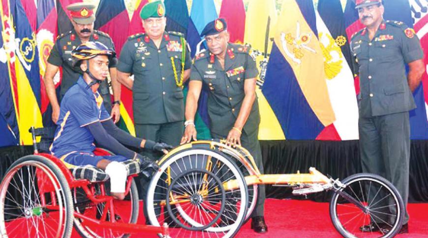 Commander of the Army, Lieutenant General Mahesh Senanayake gifts Cpl. Karunarathna a wheel chair
