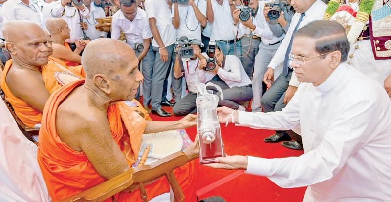 The Tripitaka was declared a national heritage at the historic Aluvihara, Matale under the patronage of President Maithripala Sirisena yesterday. Here Aloka Viharadhipathi Ven. Dr. Inamaluve Nandaratana Thera presents a set of Ola leaves where the Dhammacakkapavattana Sutta is enshrined to President Maithripala Sirisena