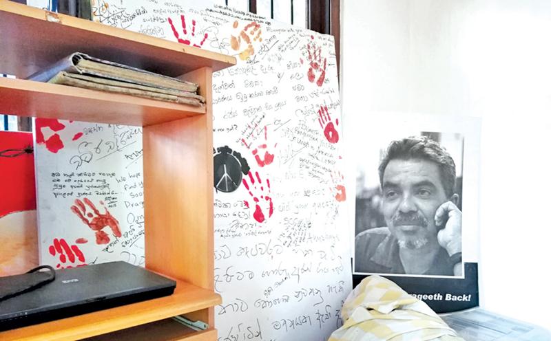 The white board signed by well-wishers and supporters on January 26, 2015, next to the large photograph  of a thoughtful Prageeth