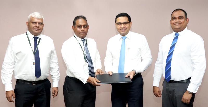 Commercial Bank Chief Operating Officer Sanath Manatunge (second from right) and Fairway Holdings Group Chief Executive officer Imal Fonseka exchange the agreement in the presence of Fairway Holdings Chief Information Officer Kumar Melvani (left) and the Bank’s Deputy General Manager, Marketing Hasrath Munasinghe.   