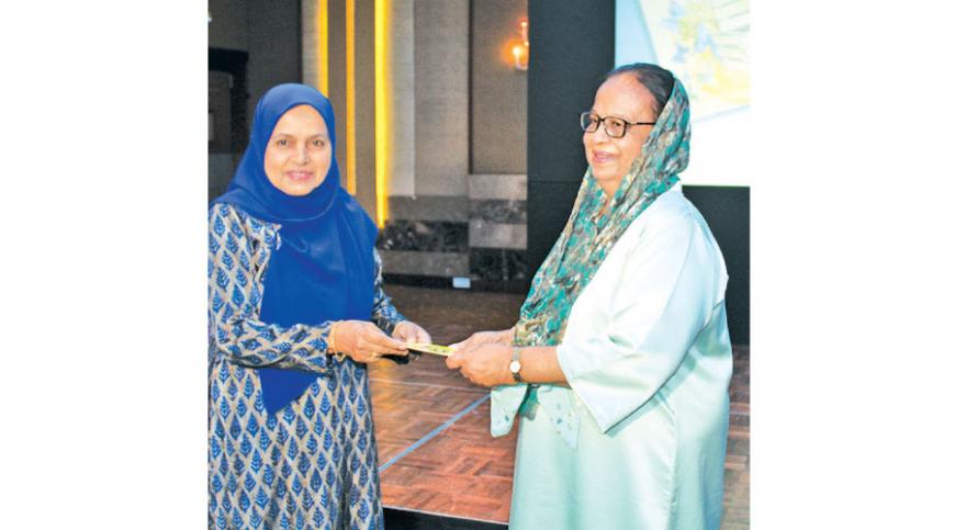 Zarina hands over the first copies of her books to Mrs. Jezima Ismail