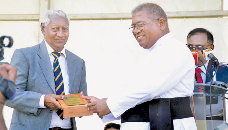 Fr Trevor Martin presents a memento to distinguish old boy of St. Peter’s College and former All Ceylon cricketer Dr HIK  Fernando (left)