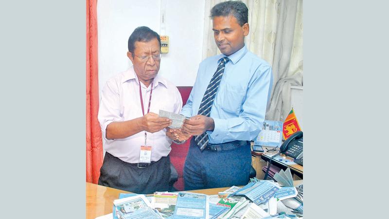 Head of Fund Management D.M. Danasena and Senior Associate Editor Sunday Observer Dudley Jansz selecting the readers’ Coupon No.11 winners of the Observer-Mobitel School Cricketer 2019 contest at Lake House (Pic by Siripala Halwala)