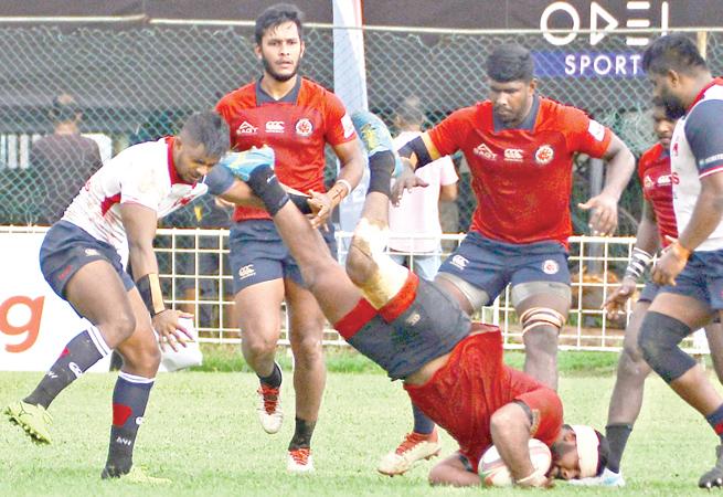 CR and FC player Omalka Gunaratne falls to the ground as his team-mates Joel Perera (right) and Rehan Silva (left) look on while Kandy’s Richard Dharmapala moves in (Picture by Thilak Perera)    