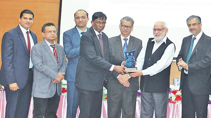 The Bank’s Deputy General Manager, Finance and Planning, Vipula Jayabahu  receives the award from the Director General of the Indian Institute  of Cost and Management Studies and Research, Dr. Asok Josh.