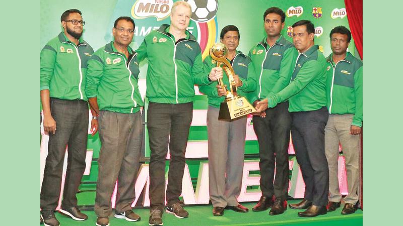 Fabrice Cavallin, (centre) Nestlé Lanka Managing Director, handing over the Milo Football Champions Trophy to Sunil Jayaweera (right), Special Consultant Sports from the Ministry of Education at the launch in the presence of Bandula Egodage, Vice-President Corporate Affairs & Communications at Nestle  