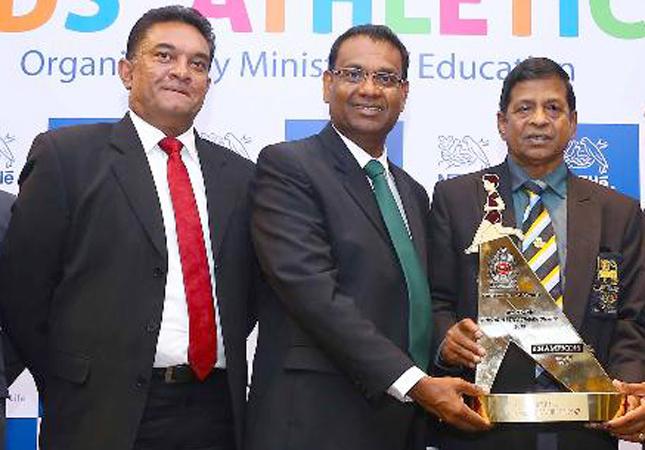 From left: Damitha Kulatunga Senior manager Corporate and Public Affairs of Nestle, Bandula Egodage Vice President Corporate Affairs of Nestle Lanka at the presentation of the trophy for Kids Athletics to Sunil Jayaweera Special Consultant Ministry of Education.     