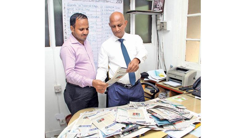 Manager Advertising Supplement Roy Jayasinghe (right) and Sports Editor Thinakaran, A.R. Fareeth selecting the Readers’ Coupon No.16 winners of Observer - Mobitel School Cricketer 2019 at Lake House. Pic by Sulochana Gamage