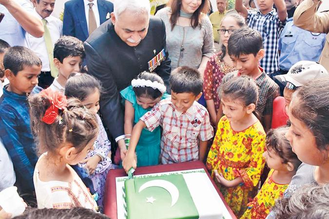 High Commissioner of Pakistan, Maj. Gen. (Rtd) Dr. Shahid Ahmad Hashmat and children cut the cake to mark Pakistan National Day.