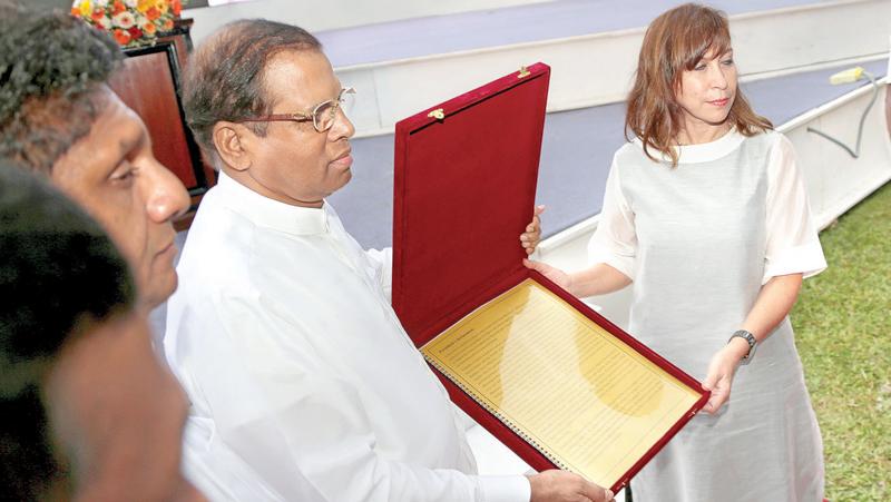 President Maithripala Sirisena handing over a request to UN Resident Coordinator Ms.Hanaa Singer seeking World Heritage recognition to the ‘Tripitaka’ - the sacred canon of Theravada Buddhism, written in Pali, at the Dalada Maligawa premises yesterday.