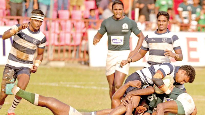 A player from St. Joseph’s College is tackled by two Isipathana defenders (Pic by Thilak Perera)