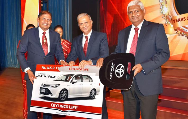 W. S. R. Fernando of Ceylinco Life’s  Negombo 01 branch (left) receives his Toyota Axio car from Chairman R. Renganathan (right) and Managing Director/CEO Thushara Ranasinghe.