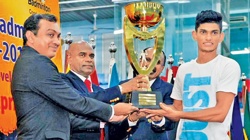 Buwaneka Gunatilleke receiving the men’s Open champions trophy from the Army Commander Lt General Mahesh Senanayake at the Defenders Open Badminton at the Army Indoor Stadium Panagoda.