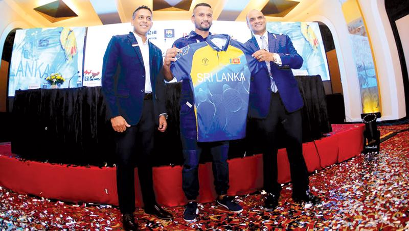 Dimuth Karunaratne poses with the miracle shirt and Shirendra Lawrence