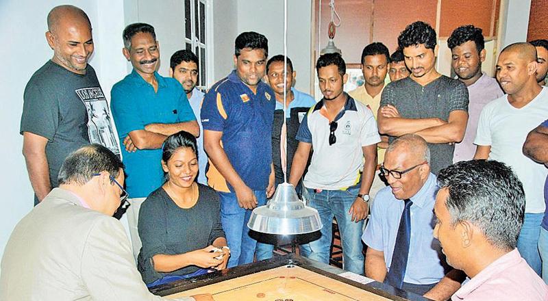 Carrom Federation president Prakrama Basnayake, Paralympic Committee president Major General Rajitha Ampemohotty and two national players Chalani Liyanage and Nishantha Fernando playing the exhibition game to mark the opening of the Premier Carrom Academy in Ganemulla