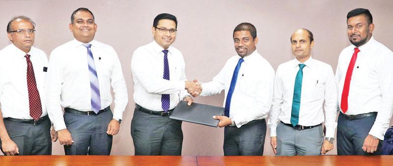 Commercial Bank’s Chief Operating Officer Sanath Manatunge (third from left) and Browns Agriculture General Manager Sanjaya Nissanka exchange the agreement. From left:  Commercial Bank’s Manager - Retail Lending Department, Chandana Abeysundara, the Bank’s Deputy General Manager, Marketing, Hasrath Munasinghe, Browns Agriculture Deputy General Manager Niyas Ahamed and Business Development Manager Chanaka Chandrasekara.